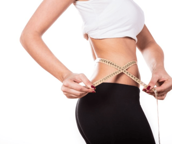 Woman measuring her slim waist after Endospheres Therapy body contouring at Novaskin in Brickell Miami
